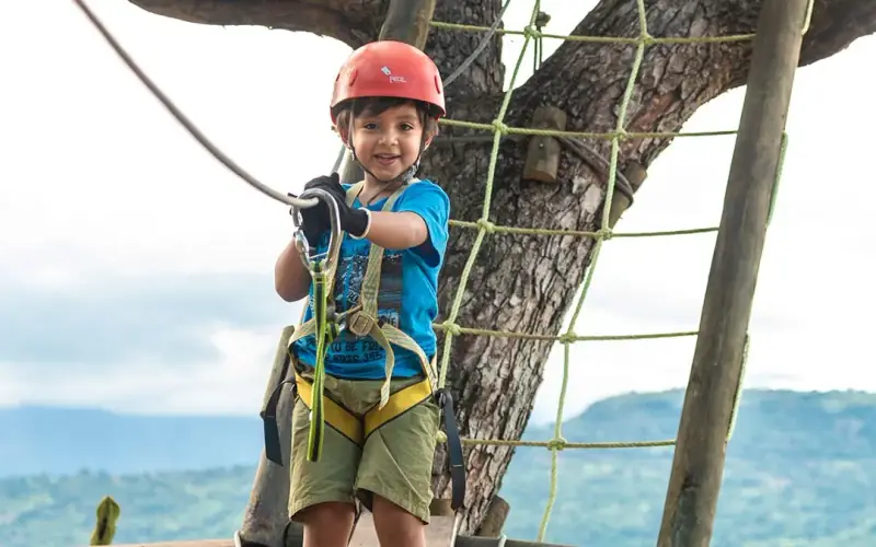 Niño con casco en un obstáculo de cuerdas