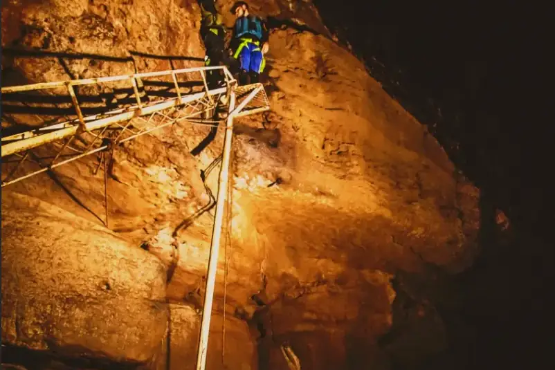 Descenso con cuerda entre las rocas iluminadas de la Cueva del Indio