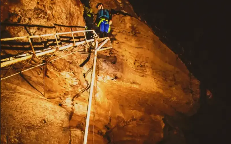 Descenso con cuerda entre las rocas iluminadas de la Cueva del Indio