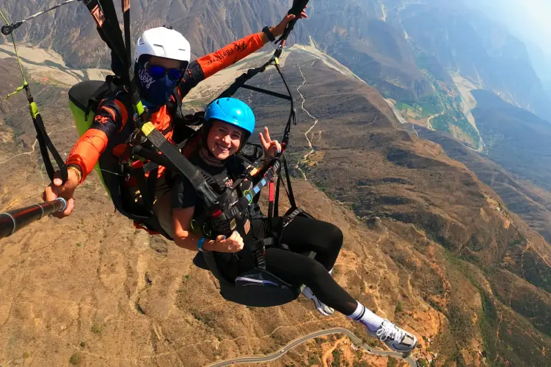 Pasajero y piloto en parapente con el cañón del Chicamocha abajo