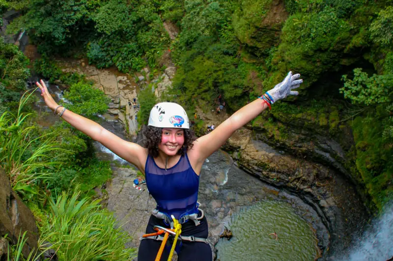 Persona con casco y arnés bajando junto a la cascada de Juan Curí