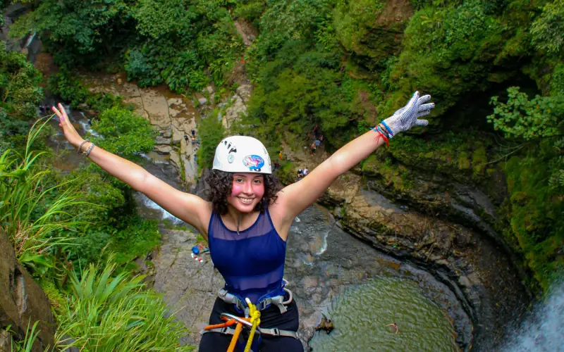 Persona con casco y arnés bajando junto a la cascada de Juan Curí